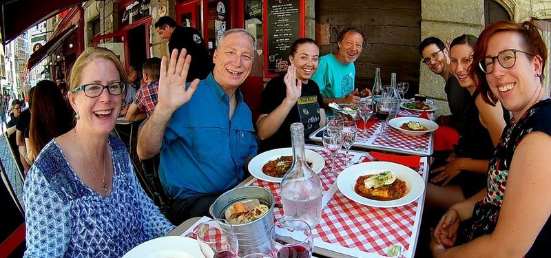 Groupe de personnes à table savourant la gastronomie lyonnaise